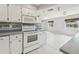 Well-lit kitchen featuring tile floors, white appliances, and modern finishes at 3067 Iverson St, Port Charlotte, FL 33952