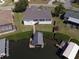 Aerial view of a home with screened in lanai, lush landscaping, and a boat dock on the water at 802 Eagle Ln, Apollo Beach, FL 33572