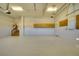 Large three-car garage featuring epoxy flooring, overhead storage, and smooth, painted walls at 802 Eagle Ln, Apollo Beach, FL 33572
