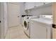 Functional laundry room with modern washer, dryer, sink and overhead cabinets, offering convenience and storage at 802 Eagle Ln, Apollo Beach, FL 33572