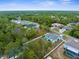 Scenic aerial view of a property with a backyard pool, surrounded by a lush, wooded neighborhood at 11344 Gallinule Ave, Weeki Wachee, FL 34613