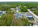 Drone shot of a property with a backyard pool surrounded by mature trees, offering privacy and seclusion at 11344 Gallinule Ave, Weeki Wachee, FL 34613