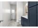 Stylish bathroom with dark blue cabinets, modern sink, and walk-in shower featuring tile and glass door at 11344 Gallinule Ave, Weeki Wachee, FL 34613