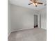 Neutral bedroom features plush carpet, ceiling fan, and an open doorway revealing the warm tones of wood flooring in another room at 11344 Gallinule Ave, Weeki Wachee, FL 34613