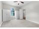 Bright bedroom with ceiling fan, plush carpet, and built-in wardrobe offers comfort and practical storage solutions at 11344 Gallinule Ave, Weeki Wachee, FL 34613