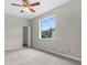 Bright bedroom with neutral paint, ceiling fan and large window providing natural light and backyard views at 11344 Gallinule Ave, Weeki Wachee, FL 34613
