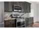 Modern kitchen features stainless steel appliances, granite countertops, and stylish dark cabinetry at 11344 Gallinule Ave, Weeki Wachee, FL 34613