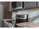 Kitchen featuring a stainless steel cooktop and oven, granite countertops, and dark wood cabinets at 11344 Gallinule Ave, Weeki Wachee, FL 34613