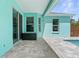 Inviting turquoise-colored patio featuring a covered area, sleek stone pavers, and a refreshing pool view at 11344 Gallinule Ave, Weeki Wachee, FL 34613