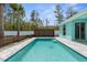 A refreshing backyard pool is framed by a wood fence, palm tree, and a vibrant, colorful house at 11344 Gallinule Ave, Weeki Wachee, FL 34613