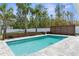 Sparkling backyard pool surrounded by lush greenery and a modern fence, offering a private and serene retreat at 11344 Gallinule Ave, Weeki Wachee, FL 34613