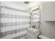 Cozy bathroom featuring a white sink, vanity, toilet, and striped shower curtain at 4125 Worcester Rd, Sarasota, FL 34231