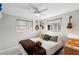 Cozy bedroom with plush bedding, two windows, ceiling fan and eclectic wall decor at 4125 Worcester Rd, Sarasota, FL 34231