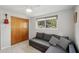 Bedroom showcases a grey pull out couch, wooden closet, and a sunny window at 4125 Worcester Rd, Sarasota, FL 34231