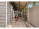 Covered carport walkway with tile pavers and utility storage in the backyard at 4125 Worcester Rd, Sarasota, FL 34231