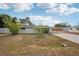 Side view of home featuring a screened-in patio and carport on a sunny day at 4125 Worcester Rd, Sarasota, FL 34231