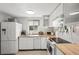 The all-white kitchen featuring butcher block countertops, updated appliances and flooring at 4125 Worcester Rd, Sarasota, FL 34231