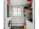 Well-lit laundry room featuring washer, dryer, shelf storage, and window at 4125 Worcester Rd, Sarasota, FL 34231