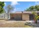 Home's back exterior features a screened-in porch and neutral colored paint at 6175 Beechwood Dr, Dade City, FL 33523