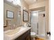 Well-lit bathroom features granite countertop vanity and tiled shower with sliding glass door at 6175 Beechwood Dr, Dade City, FL 33523