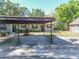 A shot of the exterior of a house with a carport and landscaping with front door view at 6175 Beechwood Dr, Dade City, FL 33523