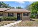 Inviting front entrance with a charming door, well-manicured bushes, and a paved walkway at 6175 Beechwood Dr, Dade City, FL 33523