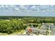 An aerial view of a newly built home community with a serene pond surrounded by lush landscaping at 17677 Nectar Flume Dr, Land O Lakes, FL 34637