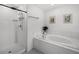 Modern bathroom featuring a separate shower and a soaking tub, accented by sleek white tile and tasteful decor at 17677 Nectar Flume Dr, Land O Lakes, FL 34637