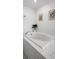 Clean, modern bathroom showcases a luxurious soaking tub with white tile surround and stylish plant decor at 17677 Nectar Flume Dr, Land O Lakes, FL 34637