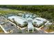 Exterior aerial showcasing a modern clubhouse surrounded by palm trees and ample parking at 17677 Nectar Flume Dr, Land O Lakes, FL 34637