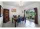 Elegant dining room with stylish blue chairs, a dark wooden table, and a picturesque backyard view at 17677 Nectar Flume Dr, Land O Lakes, FL 34637
