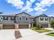 Townhouse exteriors showing garages, driveways, landscaping, and harmonious architectural design at 17677 Nectar Flume Dr, Land O Lakes, FL 34637