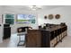 Inviting living room with comfortable seating, a large flat-screen TV, and serene views of the community pond at 17677 Nectar Flume Dr, Land O Lakes, FL 34637