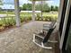 Outdoor seating area with rocking chairs and a view of community garden at 17677 Nectar Flume Dr, Land O Lakes, FL 34637