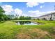 Backyard of the property features a lovely view of a pond and grassy lawn at 17677 Nectar Flume Dr, Land O Lakes, FL 34637