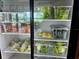 Close view of the produce refrigerator, filled with lettuce, kale, carrots, cucumbers, and cabbage at 17677 Nectar Flume Dr, Land O Lakes, FL 34637