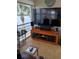 Comfortable living area with a large TV, modern wooden cabinet, and waterfront view at 4310 Falmouth Dr # 301, Longboat Key, FL 34228
