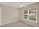 Cozy bedroom with neutral carpet, a ceiling fan, and a window providing natural light at 4804 Myrtle Oak Dr # 11, New Port Richey, FL 34653