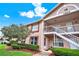 Charming condo with exterior staircase, tidy landscaping, and brick-accented facade at 4804 Myrtle Oak Dr # 11, New Port Richey, FL 34653