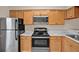 Efficient kitchen featuring stainless steel appliances, light wood cabinets, and countertops at 4804 Myrtle Oak Dr # 11, New Port Richey, FL 34653