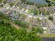 Aerial view highlighting backyard pools and neighborhood streets near a tranquil pond at 12534 Chenwood Ave, Hudson, FL 34669
