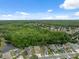 Beautiful aerial view of homes backing to a mature tree line and community pond on a sunny day at 12534 Chenwood Ave, Hudson, FL 34669