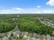 Expansive aerial view of the neighborhood with mature trees and pond, capturing community charm on a bright day at 12534 Chenwood Ave, Hudson, FL 34669