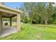 Backyard view featuring covered patio and lush greenery, creating a private oasis at 12534 Chenwood Ave, Hudson, FL 34669