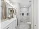Elegant bathroom with double vanity, modern fixtures, and a tiled walk-in shower with decorative inlays at 12534 Chenwood Ave, Hudson, FL 34669