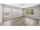 Spacious bedroom with wood-look floors, neutral paint, and natural light from two windows at 12534 Chenwood Ave, Hudson, FL 34669