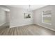 Bright dining room boasts wood-look floors, modern chandelier, and pass-through to kitchen at 12534 Chenwood Ave, Hudson, FL 34669