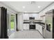 Modern kitchen featuring stainless steel appliances and white cabinets adjacent to sliding glass door at 12534 Chenwood Ave, Hudson, FL 34669