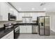 Modern kitchen with stainless steel appliances, granite countertops, and ample cabinet space at 12534 Chenwood Ave, Hudson, FL 34669
