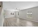Expansive living room with wood flooring, ceiling fan, and lots of natural light from large windows at 12534 Chenwood Ave, Hudson, FL 34669